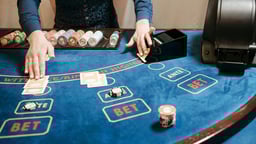 En dealer delar ut kortspel i ett parti Blackjack på ett live casino.